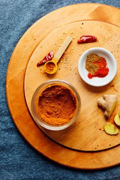 a wooden plate topped with different types of spices