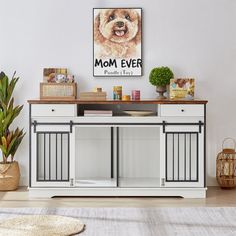 a dog is sitting on top of a white cabinet next to a potted plant