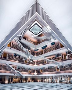 the inside of a large building with stairs and bookshelves in it's center