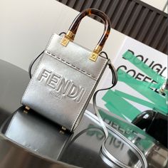 Mini Sunshine bag in off-white leather More details Sunshine mini bag in off-white leather with hot-stamped 'FENDI ROMA' lettering and rigid perspex handles in tortoiseshell effect. Featuring a lined interior compartment, it's finished with tonal leather trim and gold-tone hardware. It can be carried by hand or over the shoulder thanks to the two handles and the adjustable and detachable spaghetti shoulder strap. Made in Italy

 

Material: 100% Calfskin, 100% PMMA, Lining: 48% Nylon, 4 Luxury Silver Box Bag For Shopping, Designer Box Bag For Shopping, Top Handle Shoulder Bag With Engraved Logo, Designer Rectangular Box Bag For Shopping, Luxury Silver Box Bag, Top Handle Shoulder Bag With Engraved Logo For Shopping, Luxury Crossbody Bag With Engraved Logo, Rectangular Evening Bag With Engraved Logo, Formal Rectangular Shoulder Bag With Engraved Logo