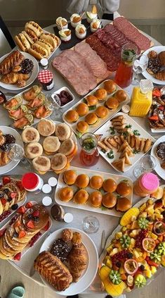 a table filled with lots of different types of food on plates and trays next to each other