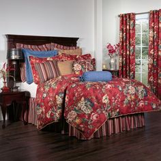 a bed room with a neatly made bed and red curtains on the window sill