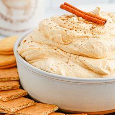 a bowl filled with whipped cream surrounded by crackers