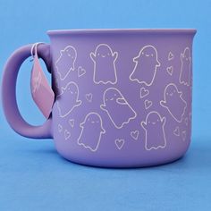 a purple coffee cup with white outline drawings on the outside and inside, in front of a blue background