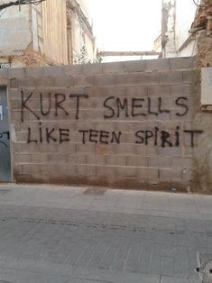 graffiti on the side of a building that says, kurt smells like teen spirit