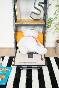 a white teddy bear sitting on top of a chair in front of a book shelf