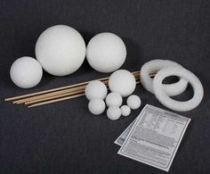 some white balls and chopsticks on a black table with paper next to them