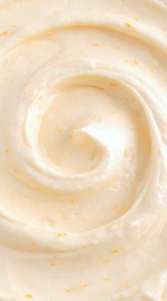 a close up view of the inside of a whipped cream cake with orange sprinkles