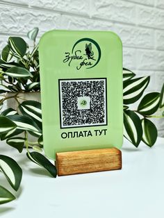 a green sign sitting on top of a wooden stand next to a potted plant