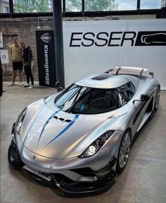 a silver sports car parked inside of a building