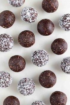 chocolate truffles with powdered sugar and sprinkles arranged on a white surface