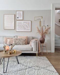 a living room filled with lots of furniture and pictures on the wall above it's coffee table