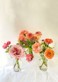 three vases filled with different colored flowers