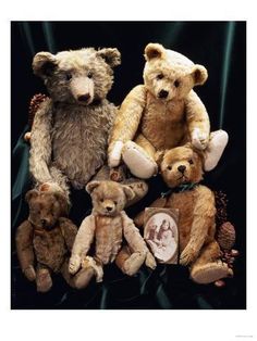 a group of teddy bears sitting next to each other on a black cloth covered background