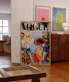 a magazine cover sitting on top of a wooden table next to a wall with pictures