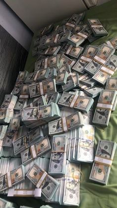 a pile of money sitting on top of a bed