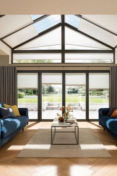 a living room filled with blue couches next to a white coffee table in front of sliding glass doors