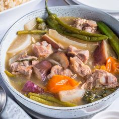 a bowl filled with meat and vegetables on top of a table