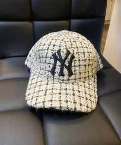 a new york yankees hat sitting on top of a black leather chair