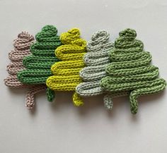 three crocheted christmas trees sitting next to each other