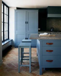 a kitchen with blue cabinets and counter tops