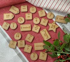 wooden numbers and place cards on a red table cloth next to some holly branches with berries