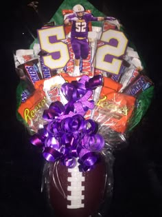 a football shaped basket filled with candy and candies for someone's 50th birthday