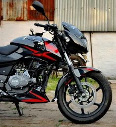 a red and black motorcycle parked in front of a building