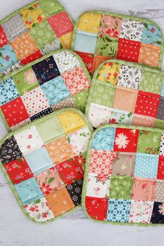 three patchwork placemats are sitting on a table top, one is green and the other is multicolored