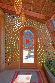 a room with a door and some lights hanging from it's ceiling, surrounded by plants