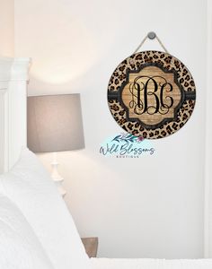 the monogrammed wooden sign is hanging on the wall next to a bed with white sheets