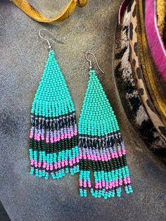 This item is available for local pick up from Magnolia, TX or select a shipping option and have it shipped directly to you. Spend over $99 and shipping is on me! Experience perfection with these charming seed bead earrings! They feature a delightful combination of turquoise, pink, black, and purple colors, adding a touch of vibrancy to your ensemble. Turquoise Beaded Earrings With Dangling Beads For Festivals, Turquoise Beaded Dangle Earrings For Festival, Turquoise Beaded Drop Earrings For Festival, Festival Turquoise Beaded Drop Earrings, Turquoise Earrings With Tiny Beads For Festivals, Pink Dangle Beaded Earrings With Black Beads, Festival Turquoise Earrings With Tiny Beads, Turquoise Beaded Earrings With Black Beads As Gift, Turquoise Earrings With Colorful Beads For Festival