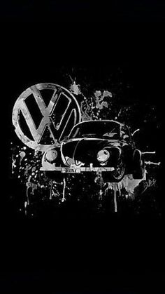 a black and white photo of an old vw bug in the dark with paint splattered on it