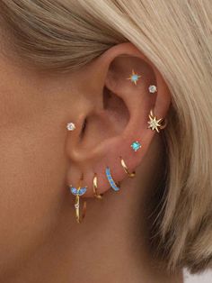 a woman wearing three different ear piercings with stars and moon designs on her ears