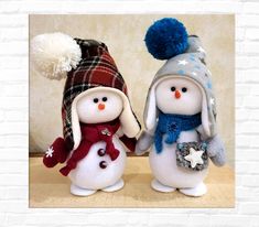 two snowmen with hats and scarves are standing next to each other