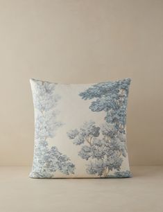 a blue and white pillow with trees on it