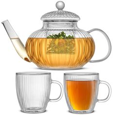 a glass tea pot and two cups filled with tea