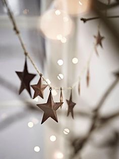 several stars hanging from a string with lights in the background