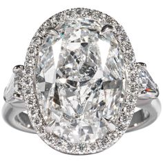 an oval cut diamond ring with three pear shaped diamonds on the band and side stones