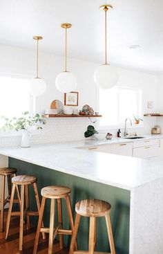 an instagram page on the iphone shows a kitchen with white countertops and wooden stools