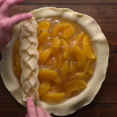 a pie crust with peaches in it being prepared to be baked into the oven