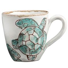 a coffee cup with a sea turtle painted on it's side and inside the cup