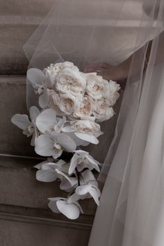 the bride's bouquet was made up of white flowers and organ - veils