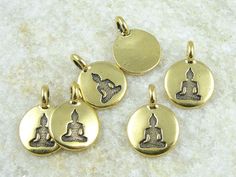 "These tiny, delicate antique gold SITTING BUDDHA pendants measure just under 1/2\" in diameter. Add them to a skinny chain for a dainty necklace. Quantity: 6 Pieces ★ Optional - upgrade to a discounted bulk bag when you add to cart. Size: 16.5mm tall, 11.5mm wide Loop Internal Diameter: 2.6mm TierraCast Part #: 94-2407-26 Finish: Antique Gold These work well with this chain: https://www.etsy.com/shop/LythaStudios/search?search_query=0725 And with TierraCast's matching charm bracelet: https://ww Antique Gold Pendant, Buddhist Symbols, Sitting Buddha, Buddha Pendant, Childrens Jewelry, Polish Jewelry, Dainty Necklace, Gold Charm, Jewelry Plate