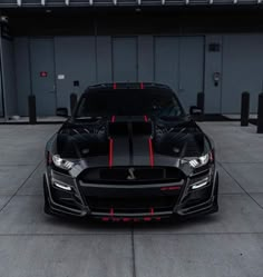 the front end of a black car with red stripes