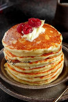 a stack of pancakes with raspberries on top