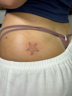 a woman with a starfish tattoo on her stomach