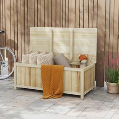 a wooden bench sitting on top of a patio next to a bike and potted plant