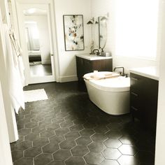 a bathroom with black and white flooring and hexagonal tiles on the floor