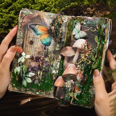 someone is holding up an altered book with mushrooms and plants